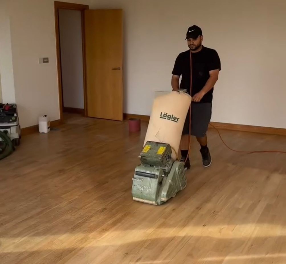Wood Floor Sanding on a light oak hardwood plank floor using a Lagler belt sander.