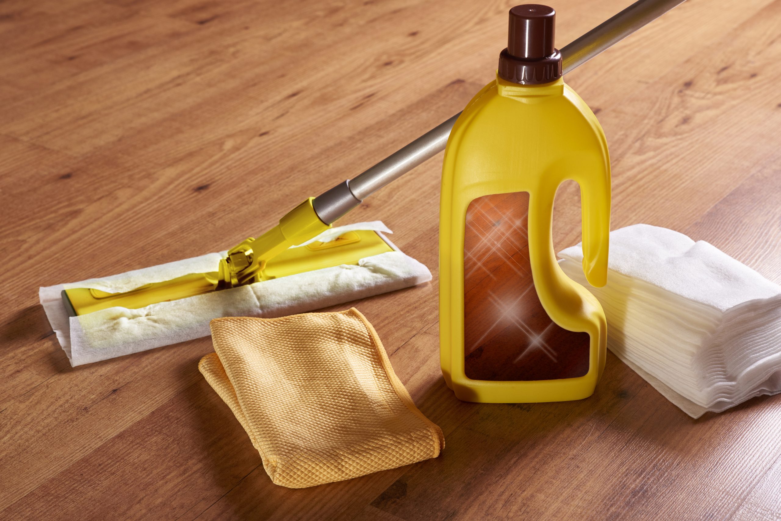 After Wood Floor Sanding care kit on restored oak plank hardwood floor with mop, cleaner and cloths.