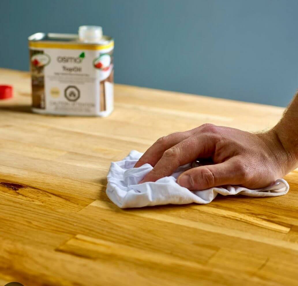 Wood Floor Sanding finish being applied with a cloth to a solid oak hardwood worktop surface.