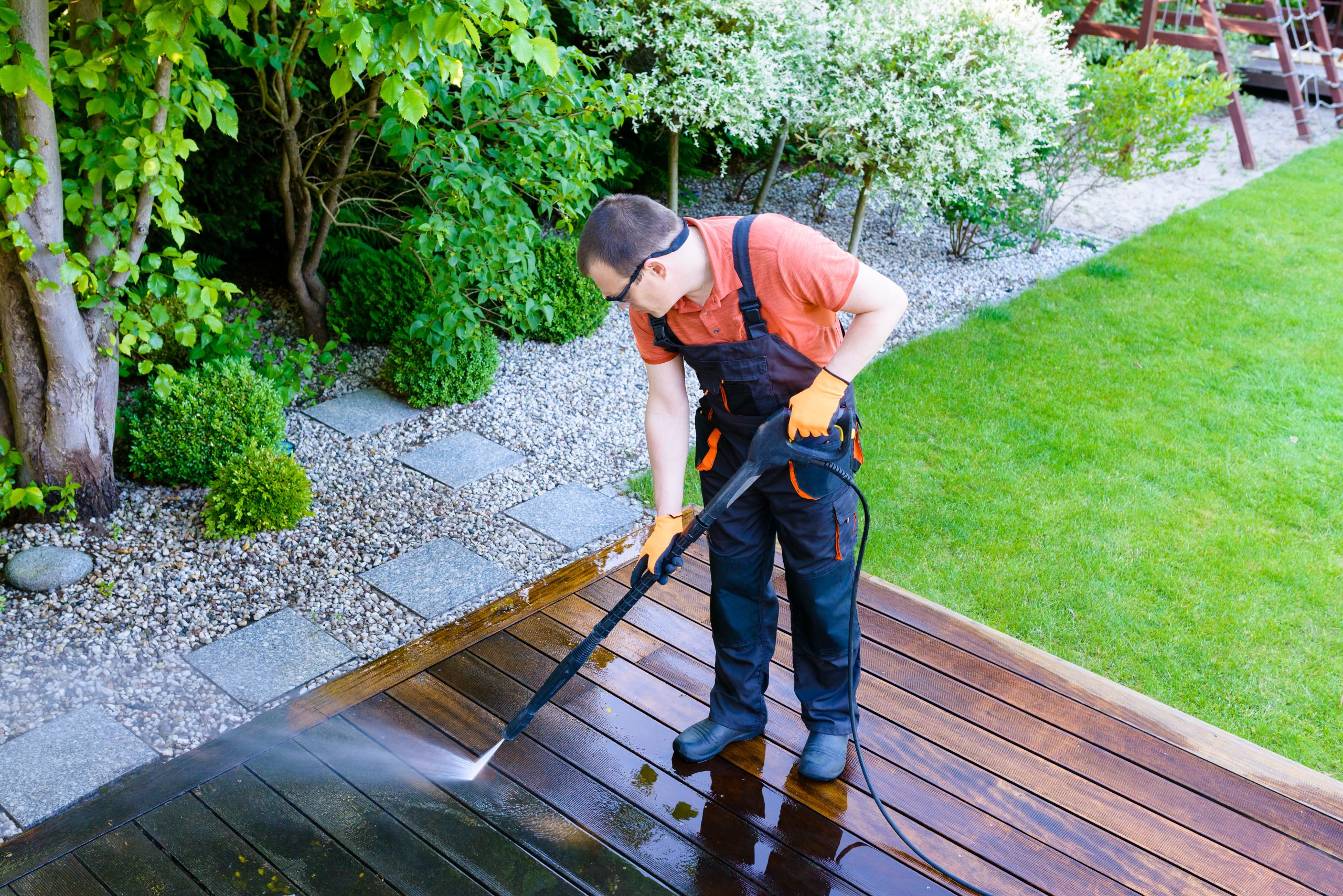 Deck Sanding in City – professional cleaning of a hardwood timber garden deck floor with a pressure washer before sanding and refinishing.