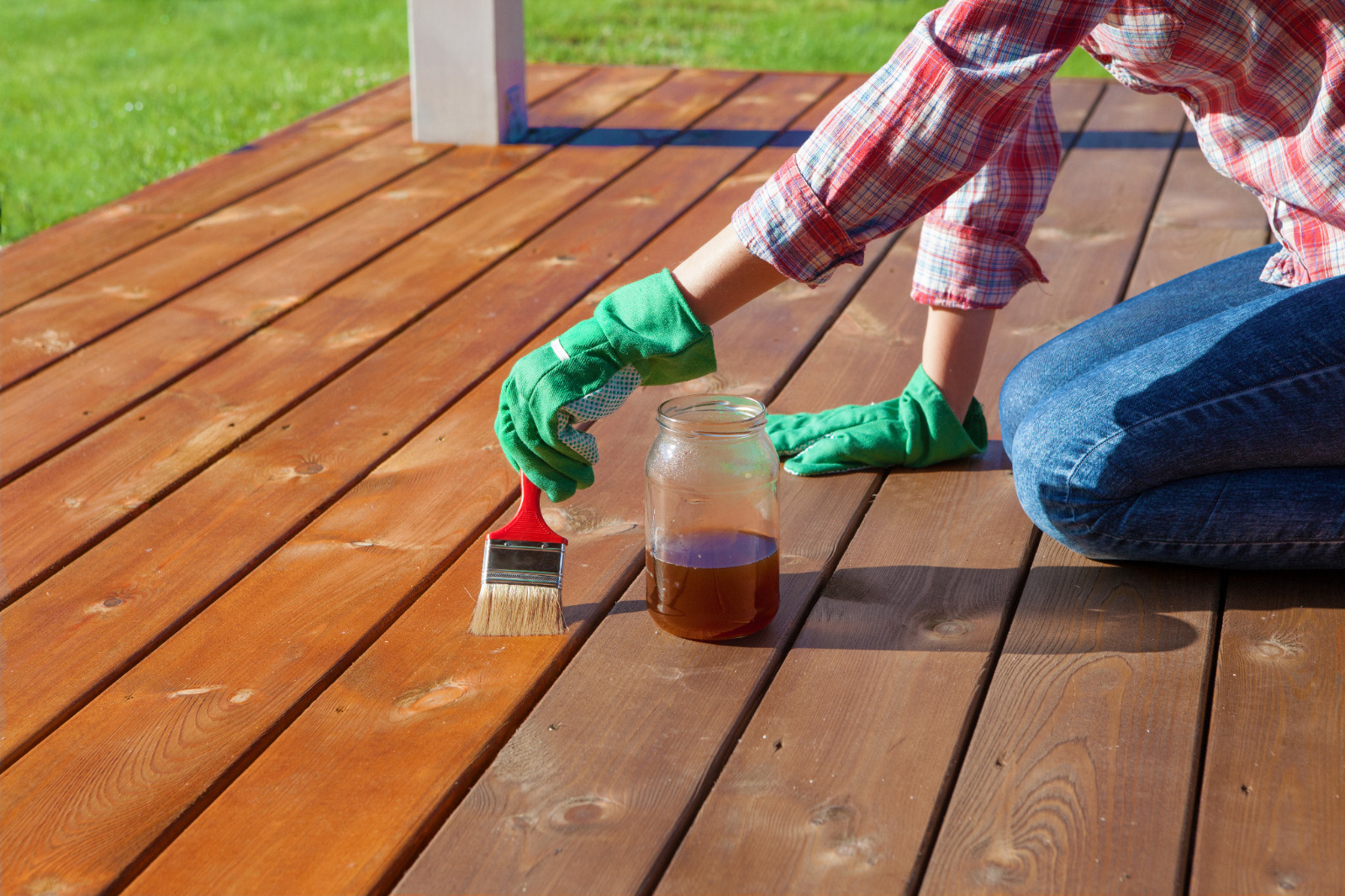 Deck Sanding in City – freshly restored softwood garden deck floor being oiled after sanding, with rich timber boards glowing in the sun.